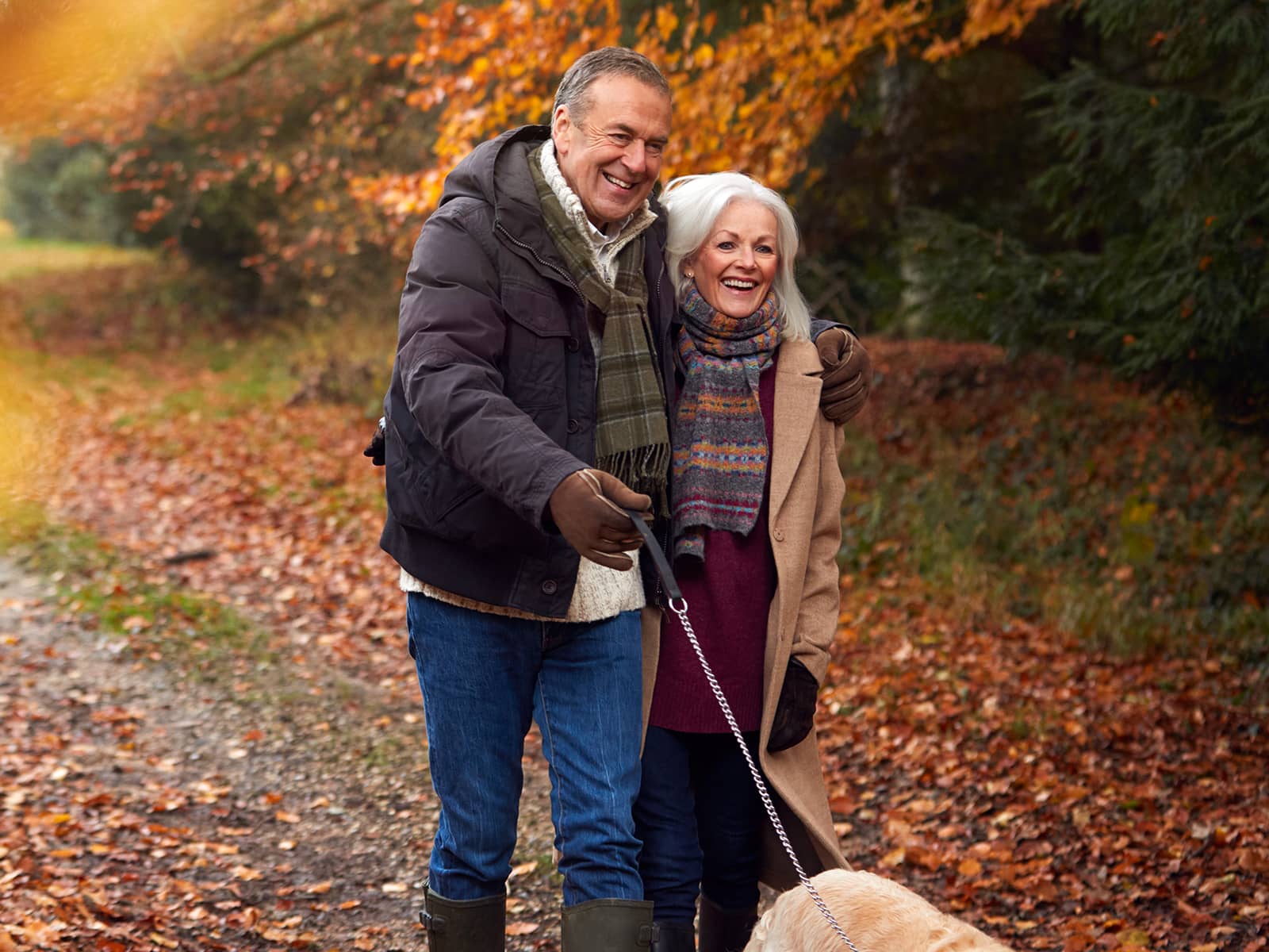 Ældre par går tur med hunden i skoven og er helt afslappet, da de har en fast pris på el. Med en fastpris  elaftale fra EWII, får de strøm til en fast pris i 12 måneder.