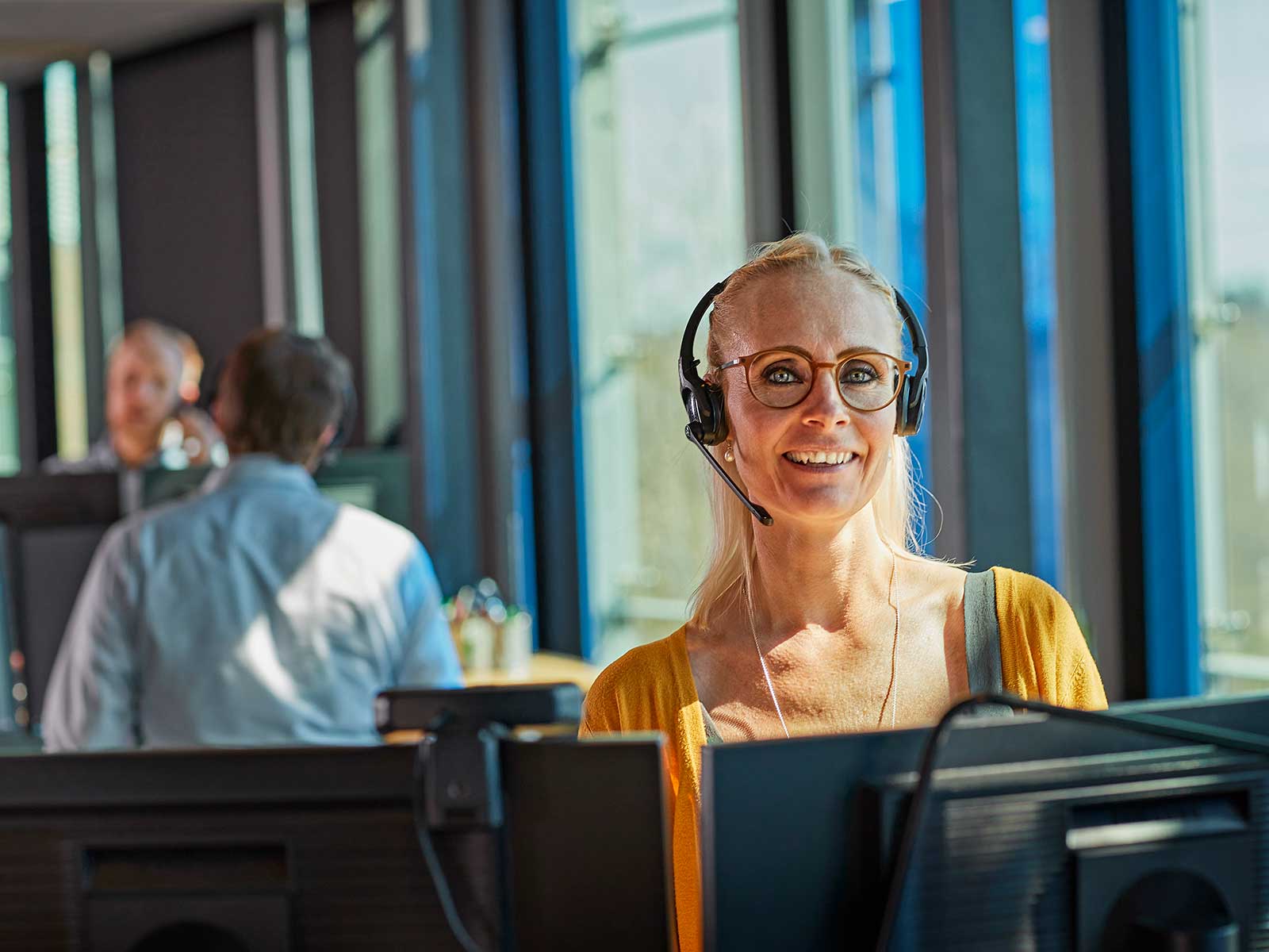 Kvinde yder rådgivning via telefon med headset