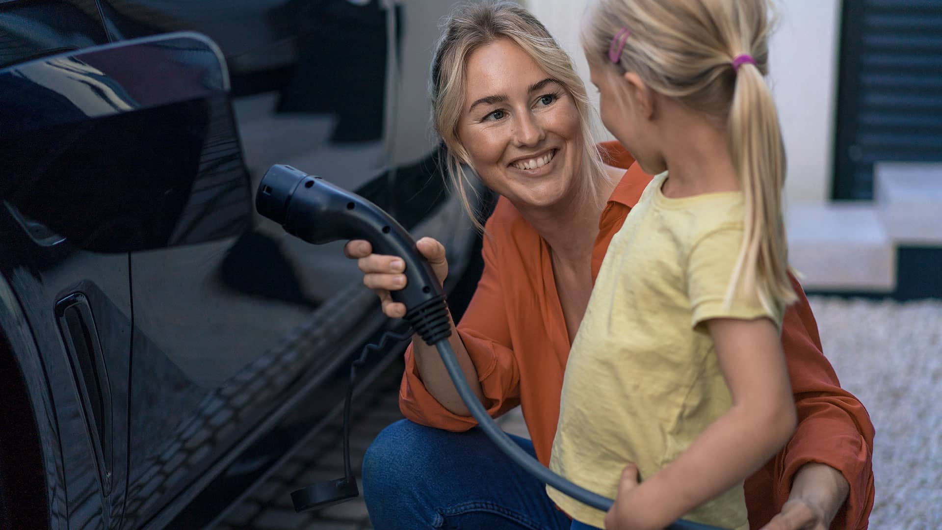 Mor og datter lader elbilen med billig grøn el til timepris, som fastsættes hver time. Således betaler hun altid for den aktuelle spotpris på el. 