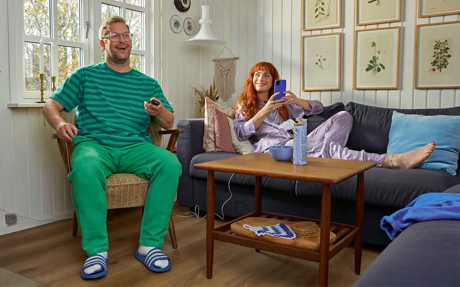 Mand og kvinde er glade fordi de ser tv i sommerhuset.