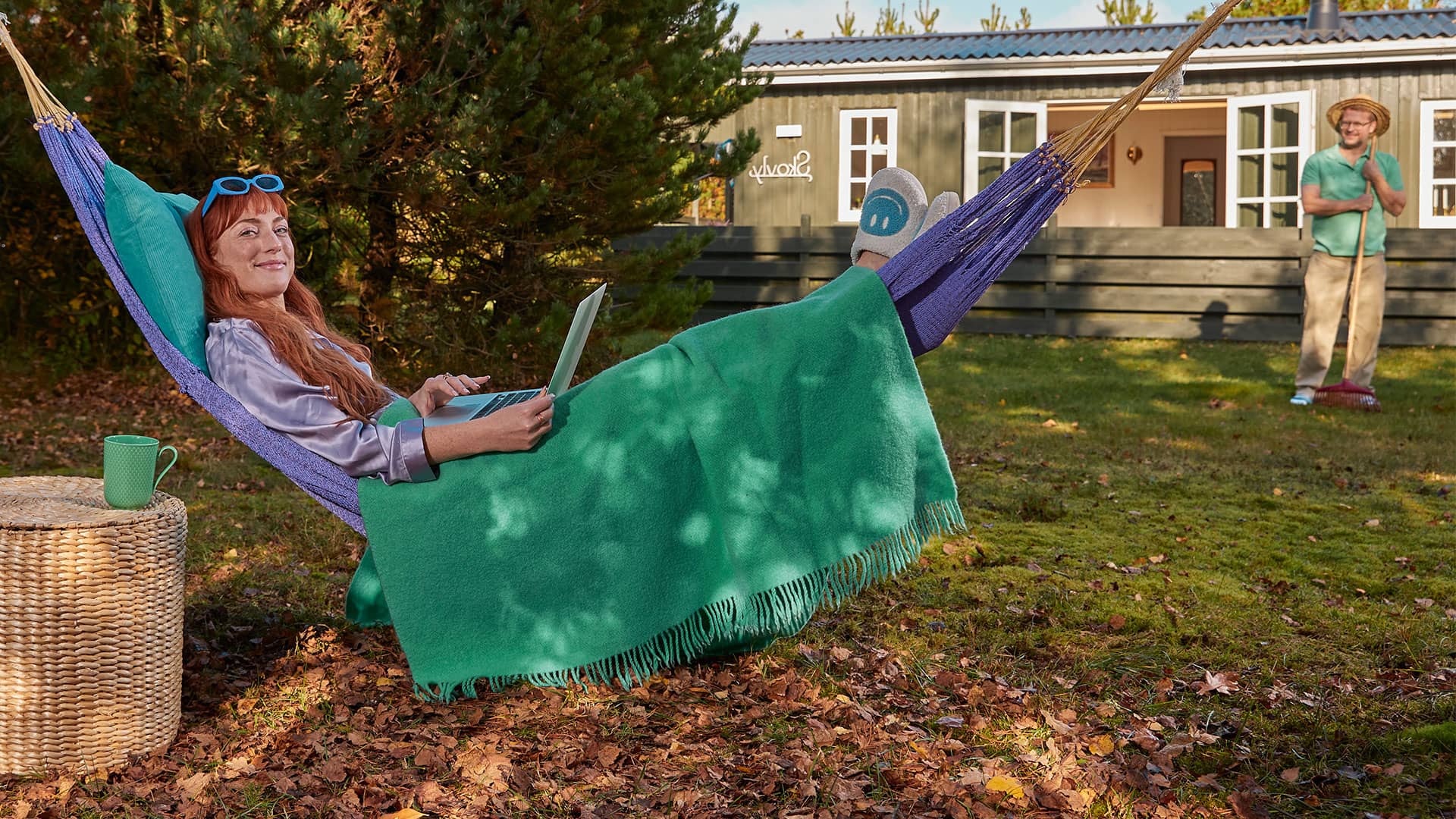 Kvinde slapper af i sin hængekøje i sit sommerhus, da hun har styr på, hvordan hun sparer på energien.