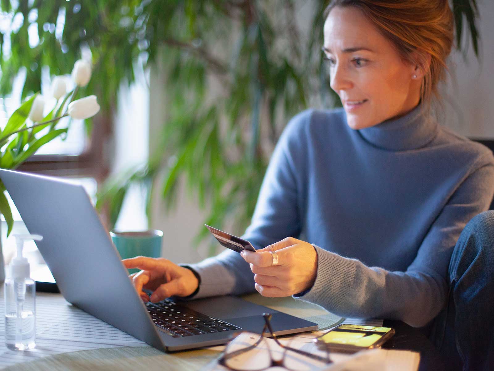 Kvinder sidder ved skrivebord og tilmelder betaling online.