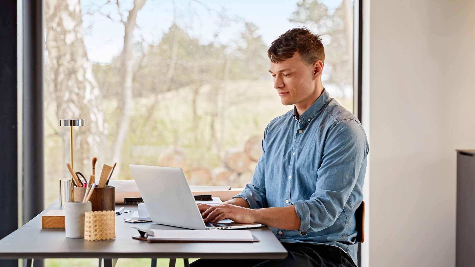 Ung mad sidder med pc og logger på selvbetjeningen. 